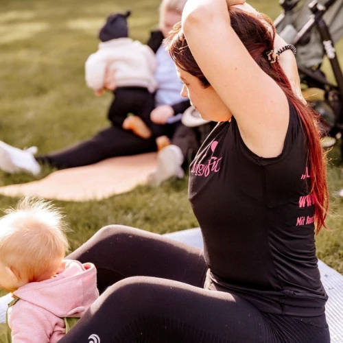 Mama beim Training mit Baby im Park